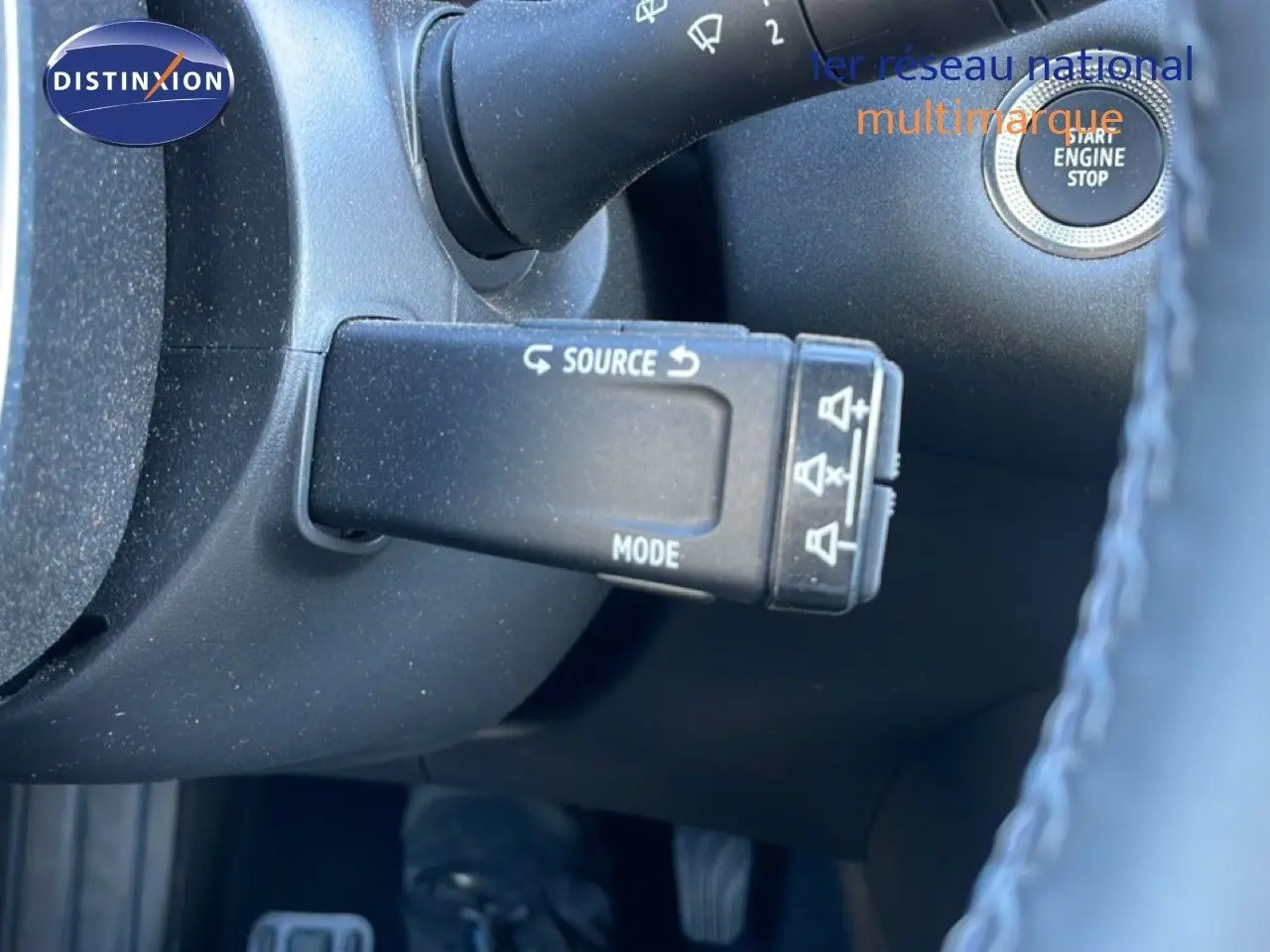 Gros plan sur la commande au volant côté gauche du Renault Captur noir étoile métal, avec bouton start/stop visible.