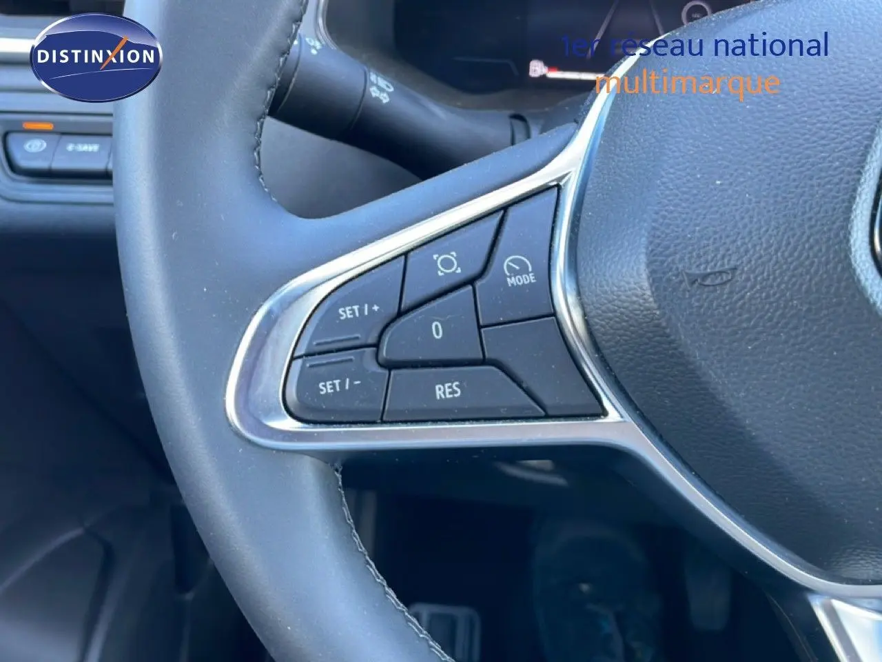 Gros plan sur les commandes au volant du Renault Captur noir étoile métal, version hybride 2025, mettant en valeur les boutons de régulateur.