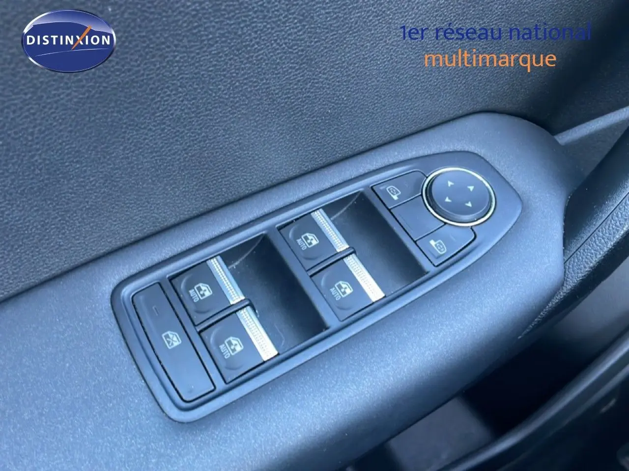 Gros plan sur les commandes des vitres électriques et rétroviseurs côté conducteur d’un Renault Captur noir étoile métal.