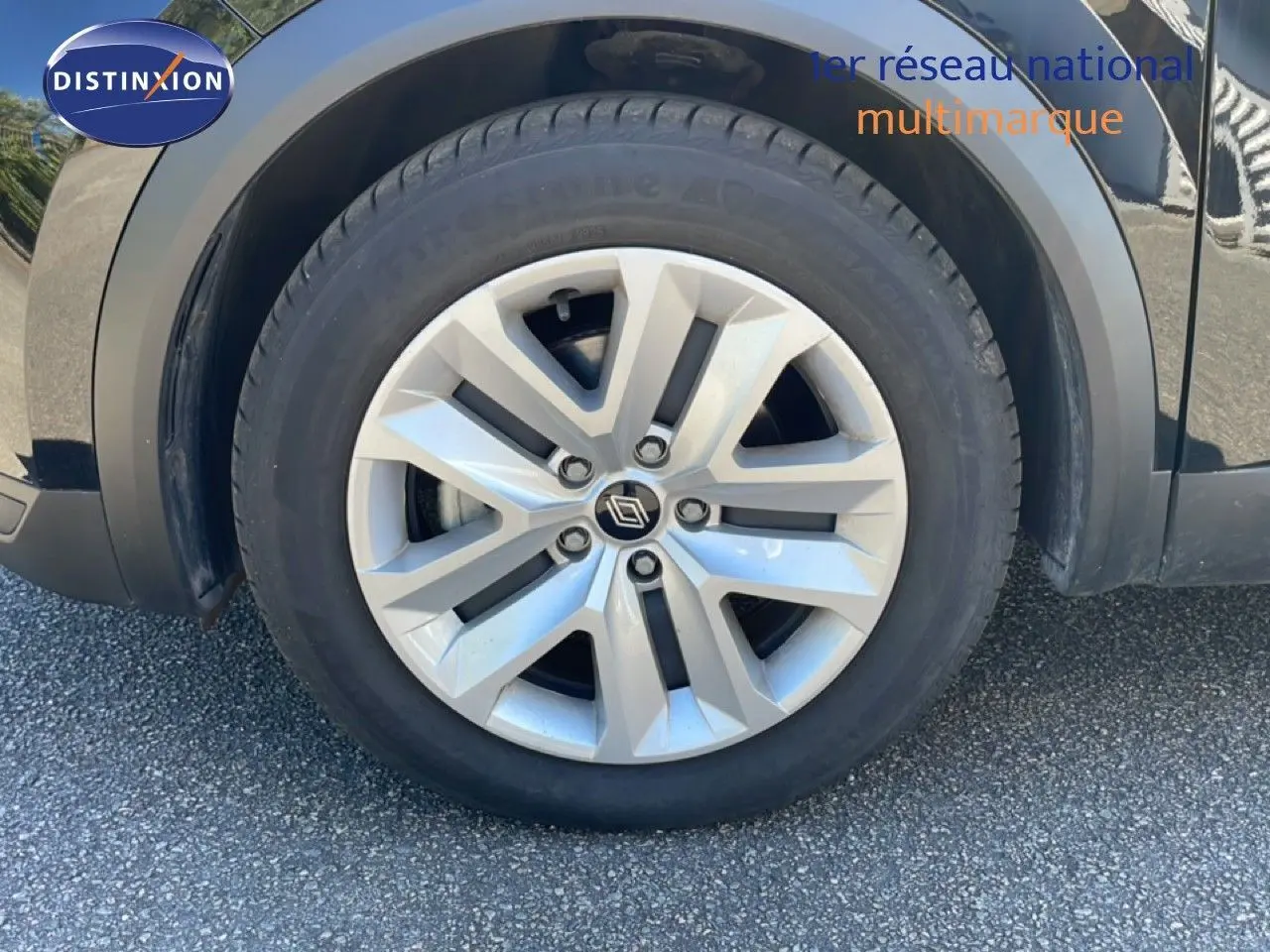 Gros plan sur la roue avant droite d’un Renault Captur noir étoile métal avec jante alliage argentée.