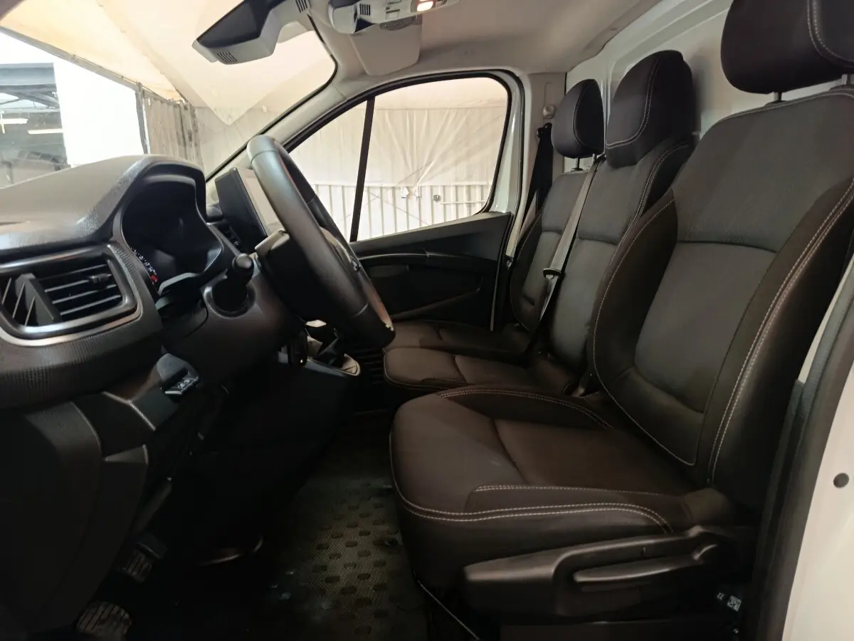 Intérieur du Renault Trafic Fourgon 2023, vue côté conducteur, sièges noirs avec volant multifonctions réglable.
