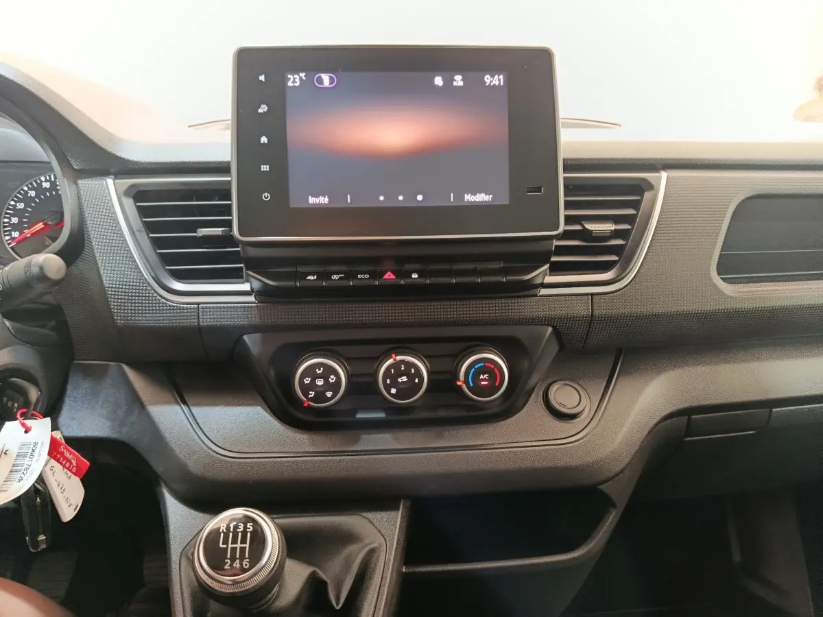 Vue intérieure du tableau de bord du Renault Trafic Fourgon 2023, avec écran tactile et levier de vitesses manuel.