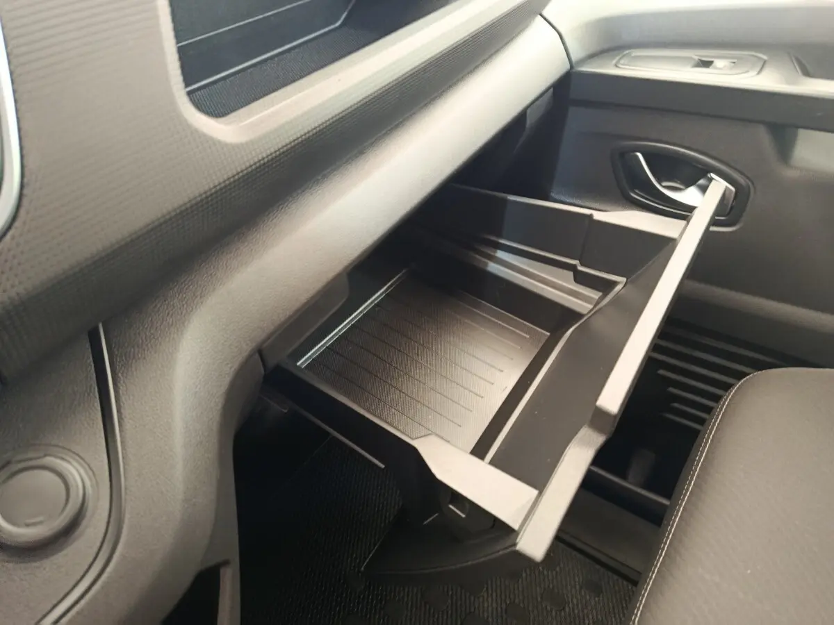 Vue intérieure côté passager du Renault Trafic Fourgon 2023, boîte à gants ouverte en plastique noir.