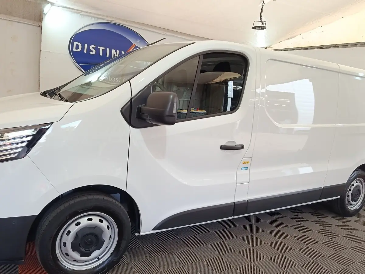 Vue de profil côté gauche d'un Renault Trafic Fourgon blanc avec jantes acier et rétroviseurs noirs.