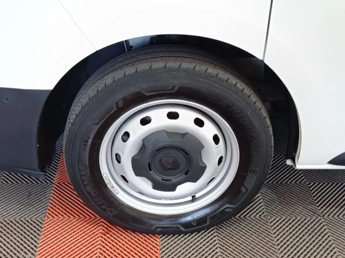 Gros plan sur la roue avant droite en jante acier du Renault Trafic Fourgon blanc, avec pneu Bridgestone.