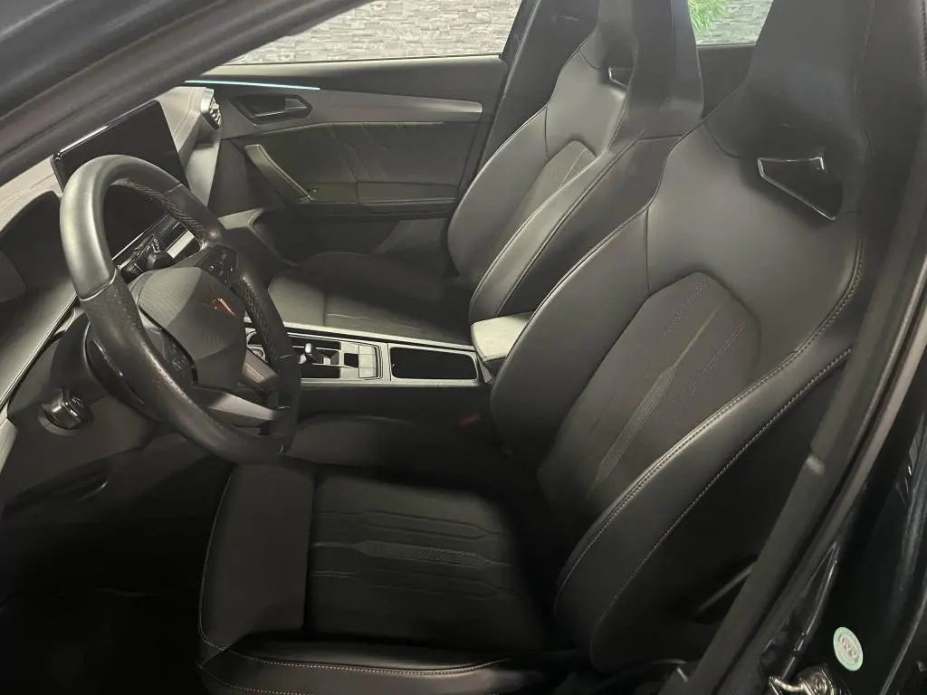 Intérieur avant du CUPRA Formentor 1.4 e-Hybrid 2023, sièges baquets noirs et volant sport multifonction cuir.