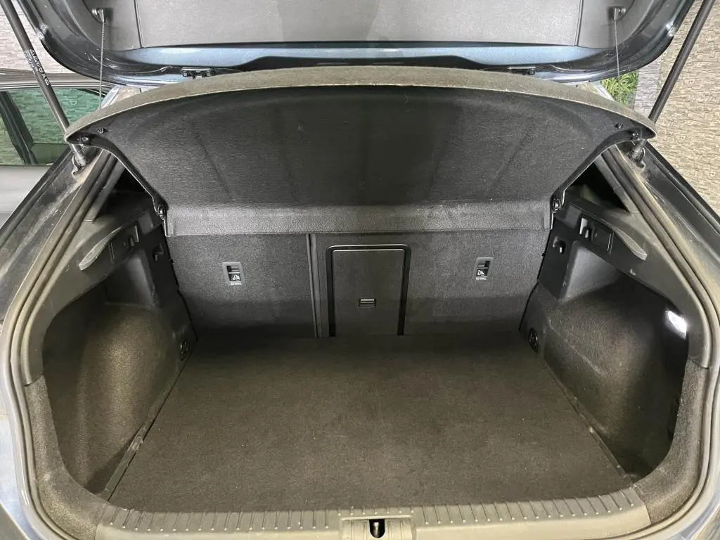 Coffre ouvert vu de l'arrière du CUPRA Formentor gris, montrant un espace de chargement propre et bien fini.