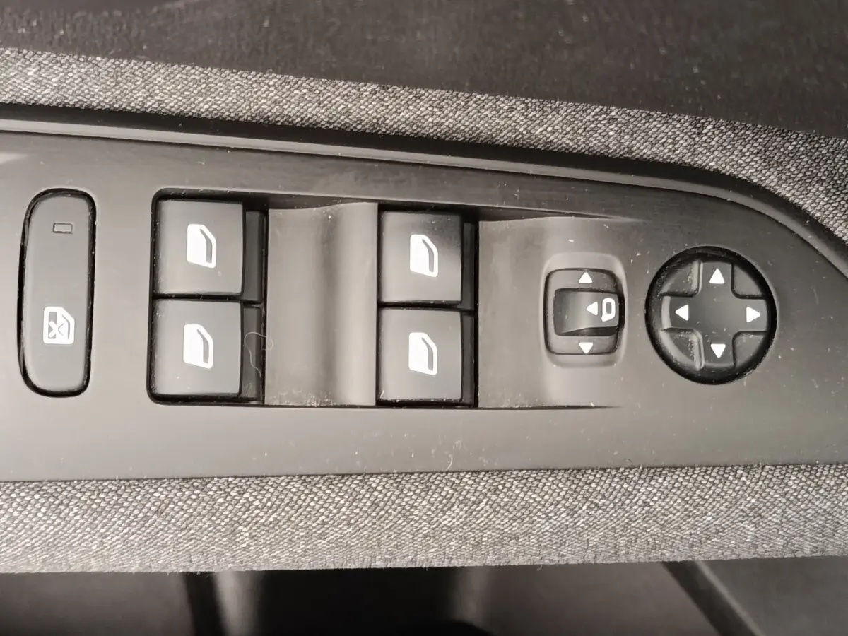 Gros plan sur les commandes électriques des vitres et rétroviseurs côté conducteur du Peugeot 5008 gris foncé, version 2020.