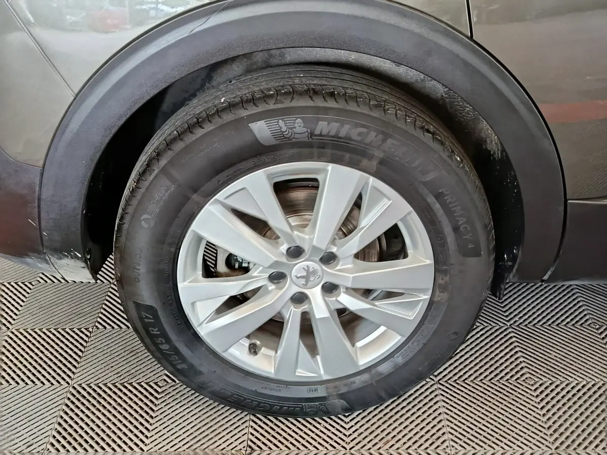 Gros plan sur la roue avant gauche grise d’un Peugeot 5008 2020 avec jante alliage et pneu Michelin.