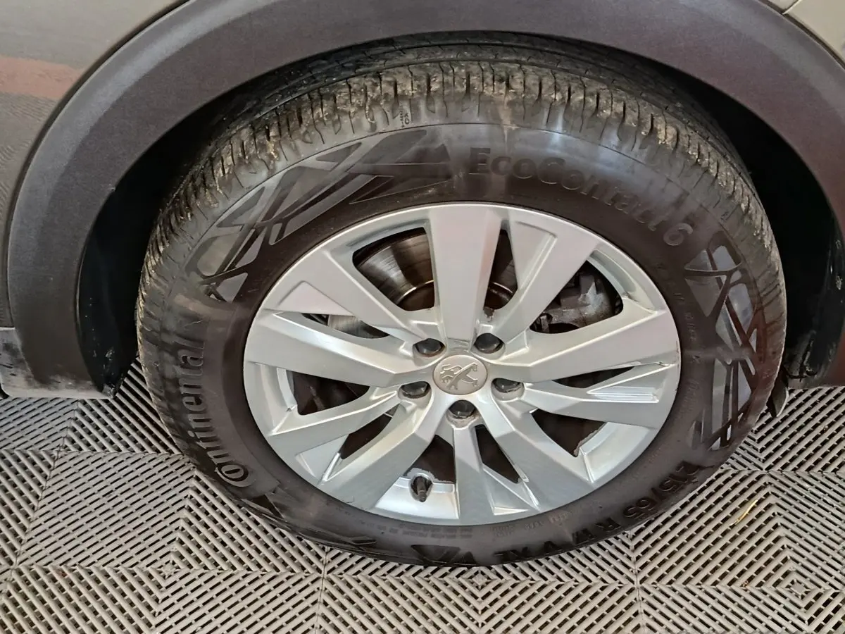 Gros plan sur la roue avant gauche du Peugeot 5008 gris foncé, avec jante alliage et pneu Continental EcoContact 6.