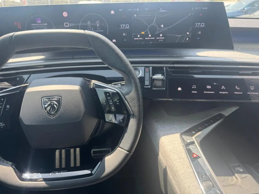 Vue intérieure centrée sur le volant noir du Peugeot 3008 Hybrid GT avec cockpit numérique et commandes tactiles.