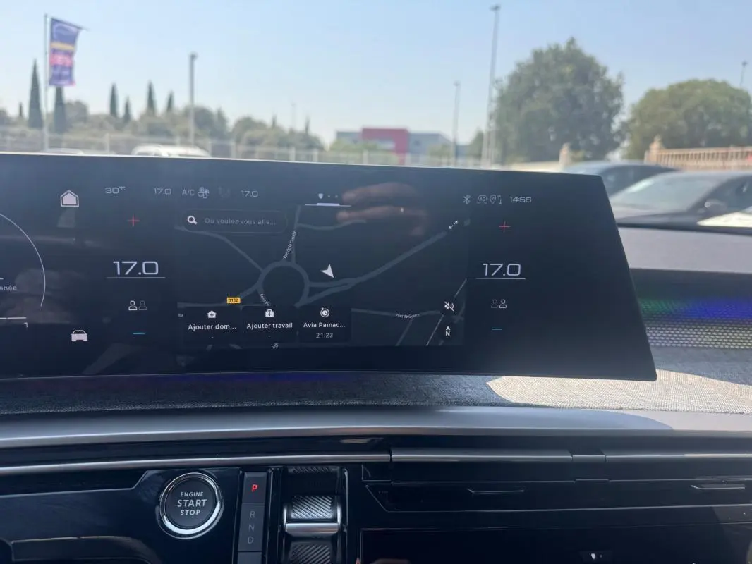 Vue rapprochée du tableau de bord numérique du Peugeot 3008 Hybrid 145 e-DCS6 GT noir, affichant la navigation et la climatisation.