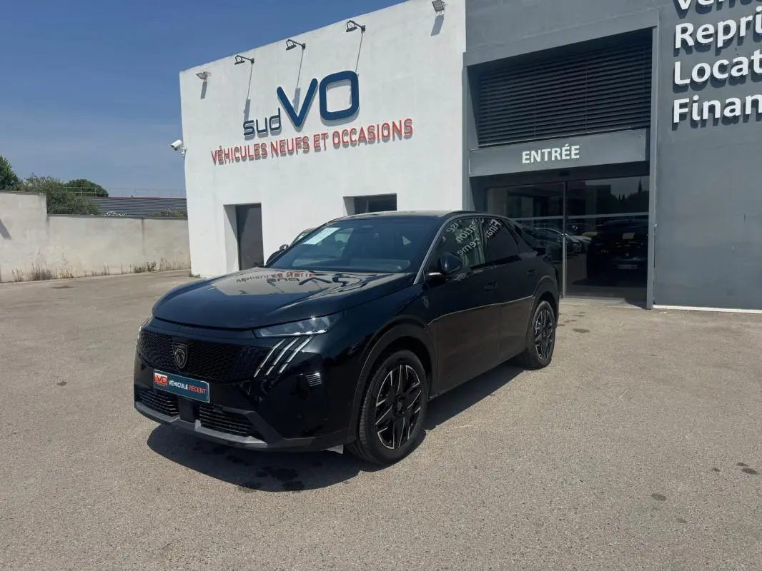 Vue 3/4 avant d'un Peugeot 3008 Hybrid 145 e-DCS6 GT noir, avec jantes alliage 19 pouces, devant un concessionnaire.