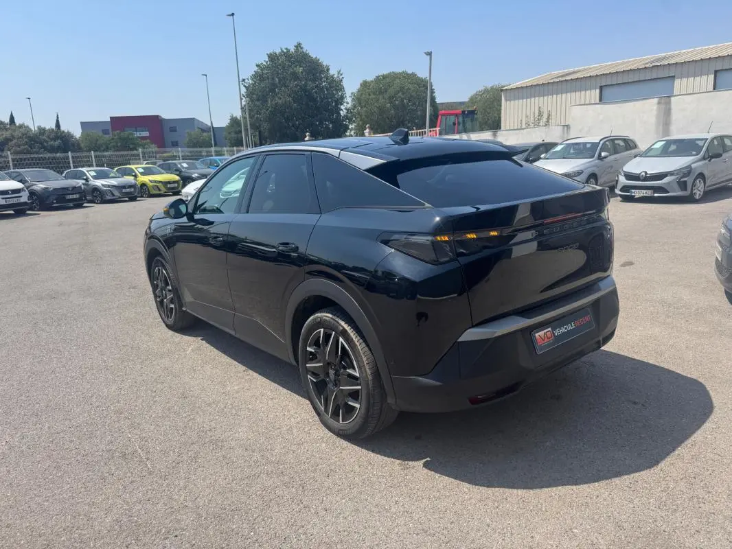 Vue 3/4 arrière droite d'un Peugeot 3008 Hybrid noir avec jantes alliage 19 pouces, stationné en extérieur.