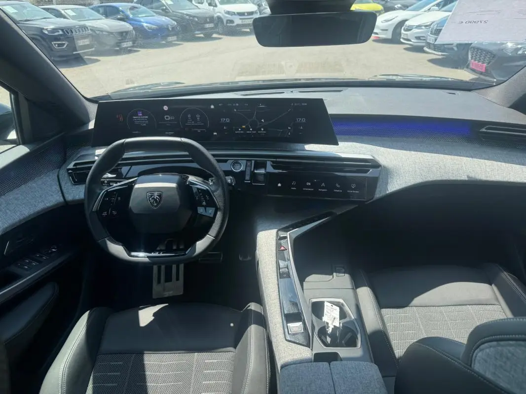 Vue intérieure du poste de conduite du Peugeot 3008 Hybrid 145 e-DCS6 GT 2025, avec cockpit numérique et volant compact.