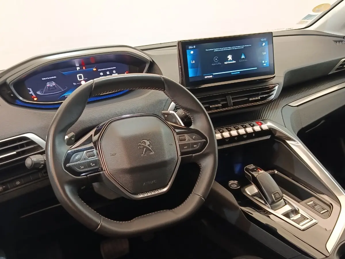Vue intérieure centrée sur le volant cuir Peugeot et l’écran tactile du tableau de bord du 3008 noir 2022.