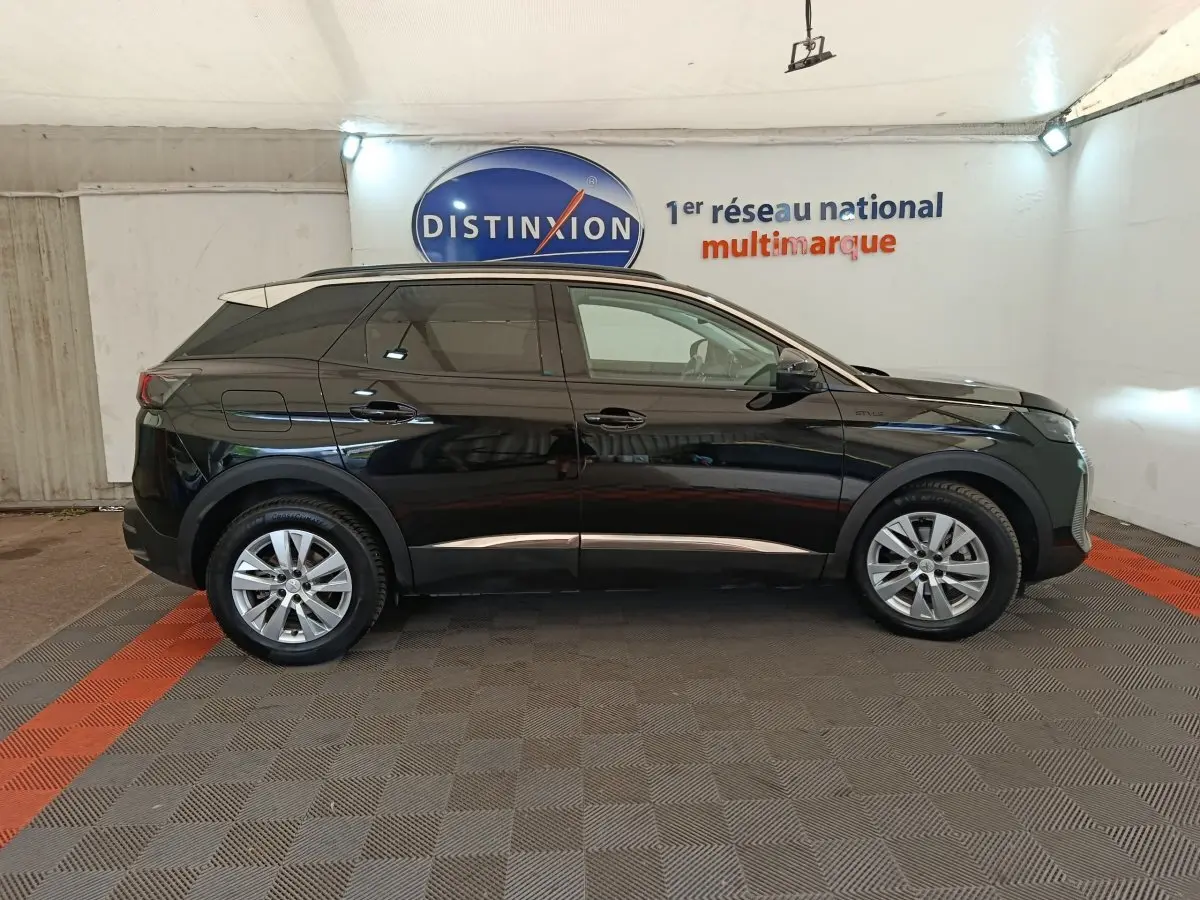 Profil côté gauche d’un Peugeot 3008 noir 2022, version BlueHDi 130 Style, dans un showroom avec sol gris et bandes rouges.