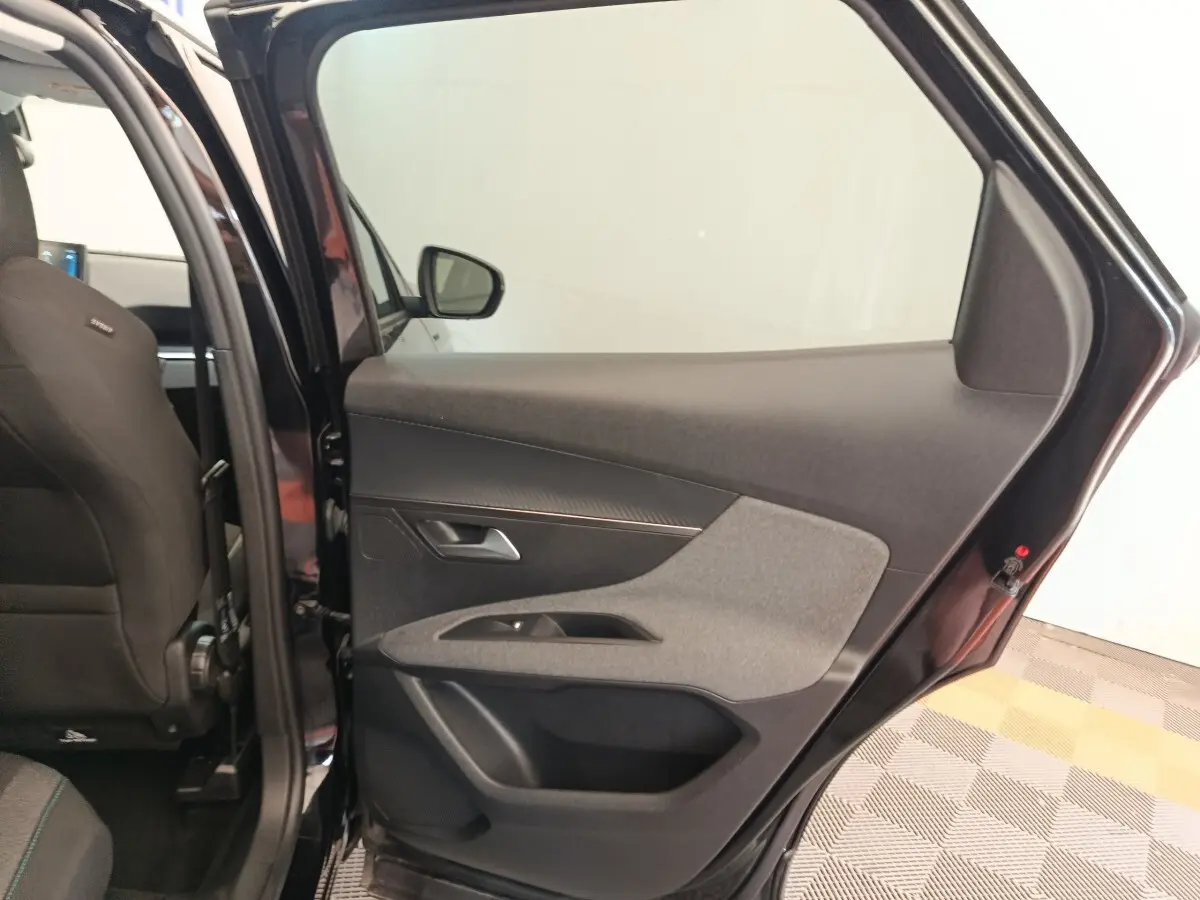 Vue intérieure côté droit de la porte arrière noire du Peugeot 3008 2022 avec garniture tissu et plastique.