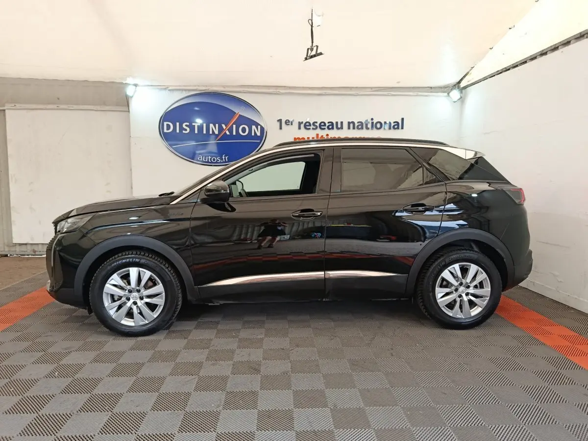 Peugeot 3008 noir vue profil côté gauche, SUV compact avec jantes alliage et vitres teintées en intérieur showroom.