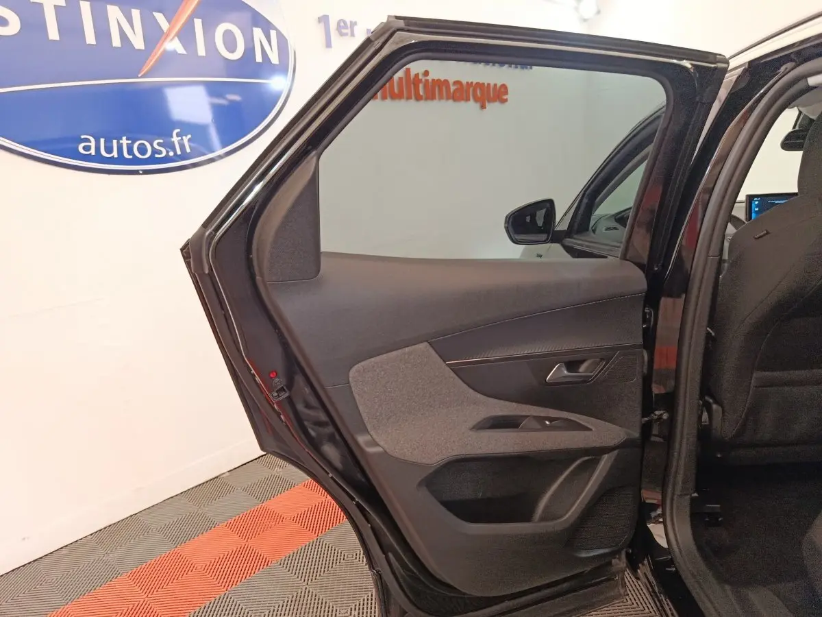 Vue intérieure de la porte arrière gauche ouverte d’un Peugeot 3008 noir, montrant les garnitures et la poignée.