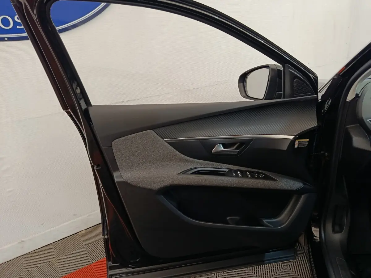 Vue intérieure de la porte avant gauche noire du Peugeot 3008 2022 avec commandes de vitres et insert décoratif gris.