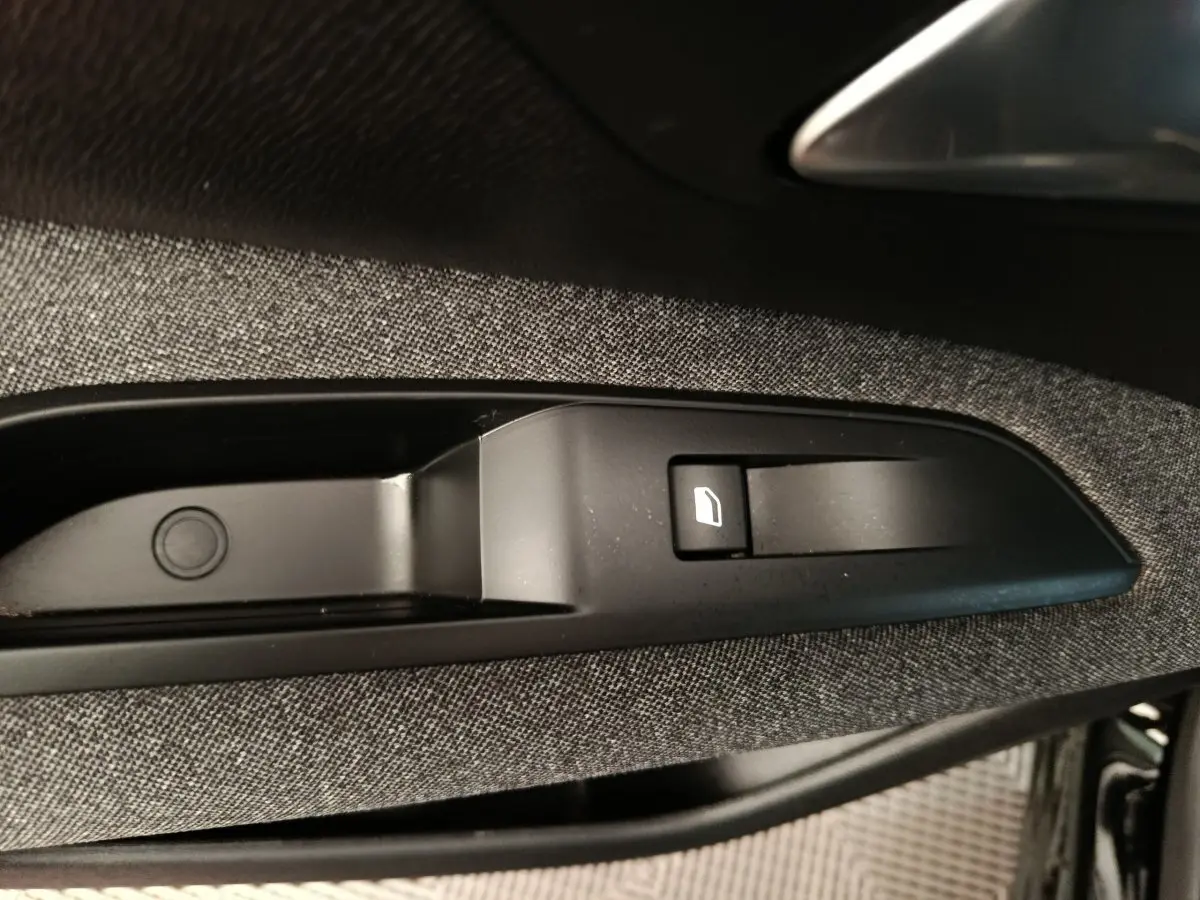 Détail de la commande de lève-vitre sur la porte côté conducteur du Peugeot 3008 noir 2022.