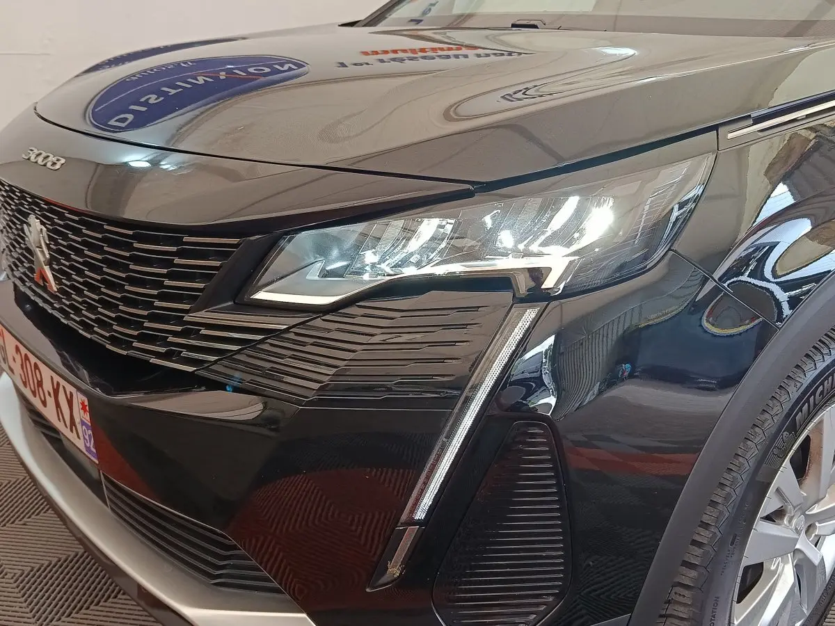 Vue 3/4 avant droit d’un Peugeot 3008 noir 2022 avec phares LED allumés et calandre distinctive.