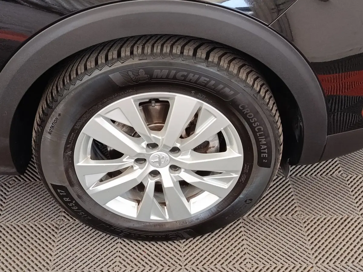 Gros plan sur la roue avant droite d’un Peugeot 3008 noir, pneu Michelin CrossClimate 17 pouces.