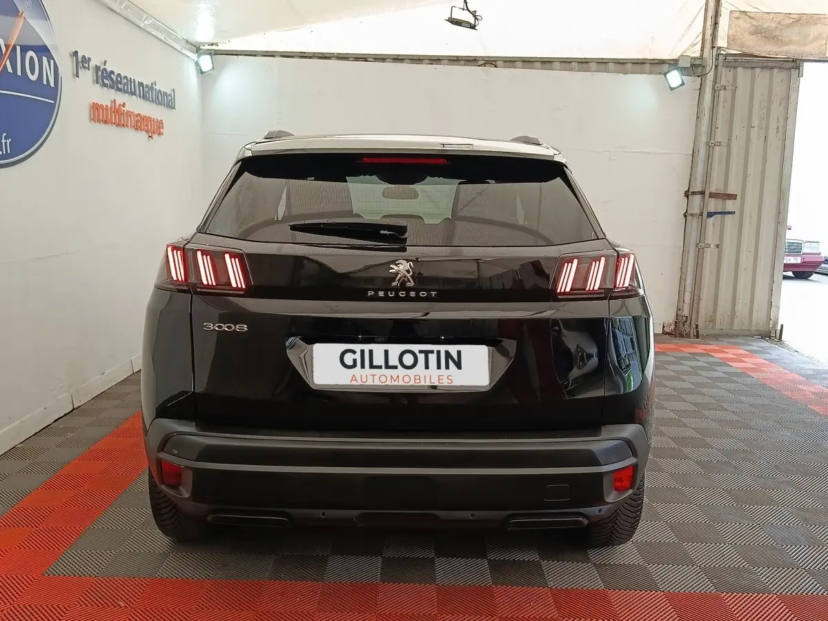 Vue arrière d’un Peugeot 3008 noir 2022 avec feux LED caractéristiques et logo central sur fond brillant.