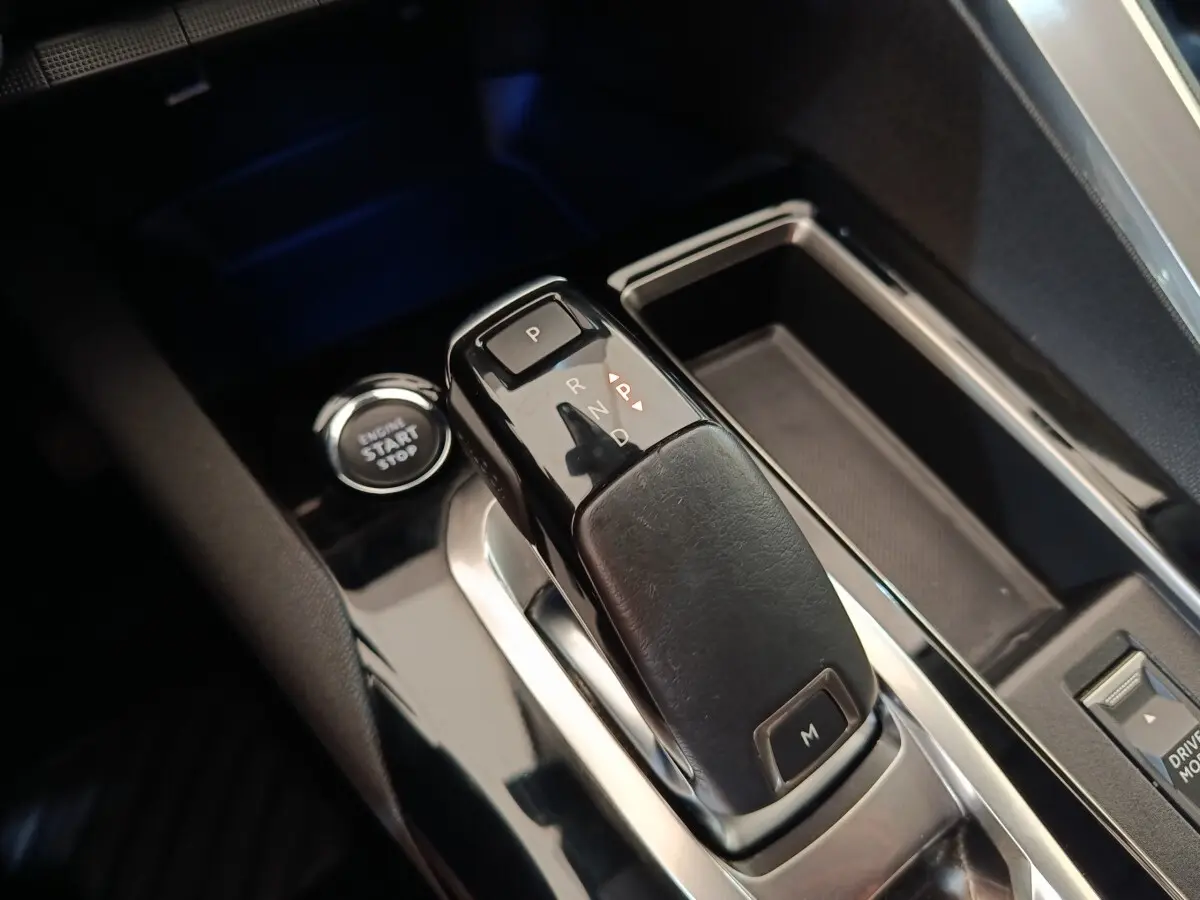 Gros plan sur la commande de boîte automatique et bouton start/stop du Peugeot 3008 noir, intérieur moderne et soigné.
