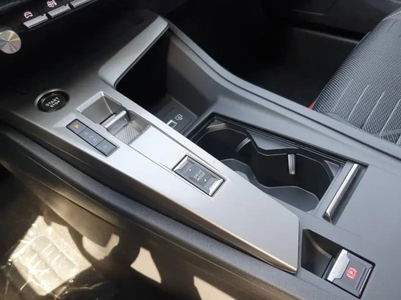 Vue rapprochée de la console centrale grise avec levier de vitesse électronique et bouton Start/Stop dans une Peugeot 308 blanche.