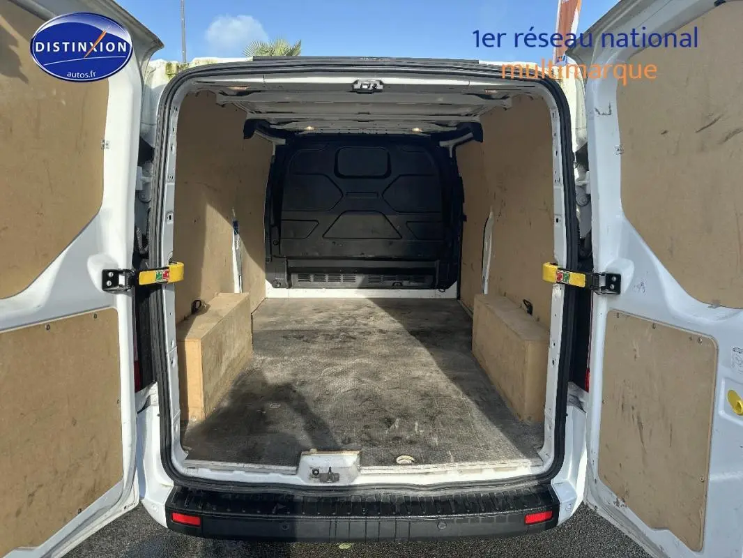 Vue arrière ouverte du fourgon blanc Ford Transit Custom 2021 montrant l'espace de chargement vide et les portes battantes.