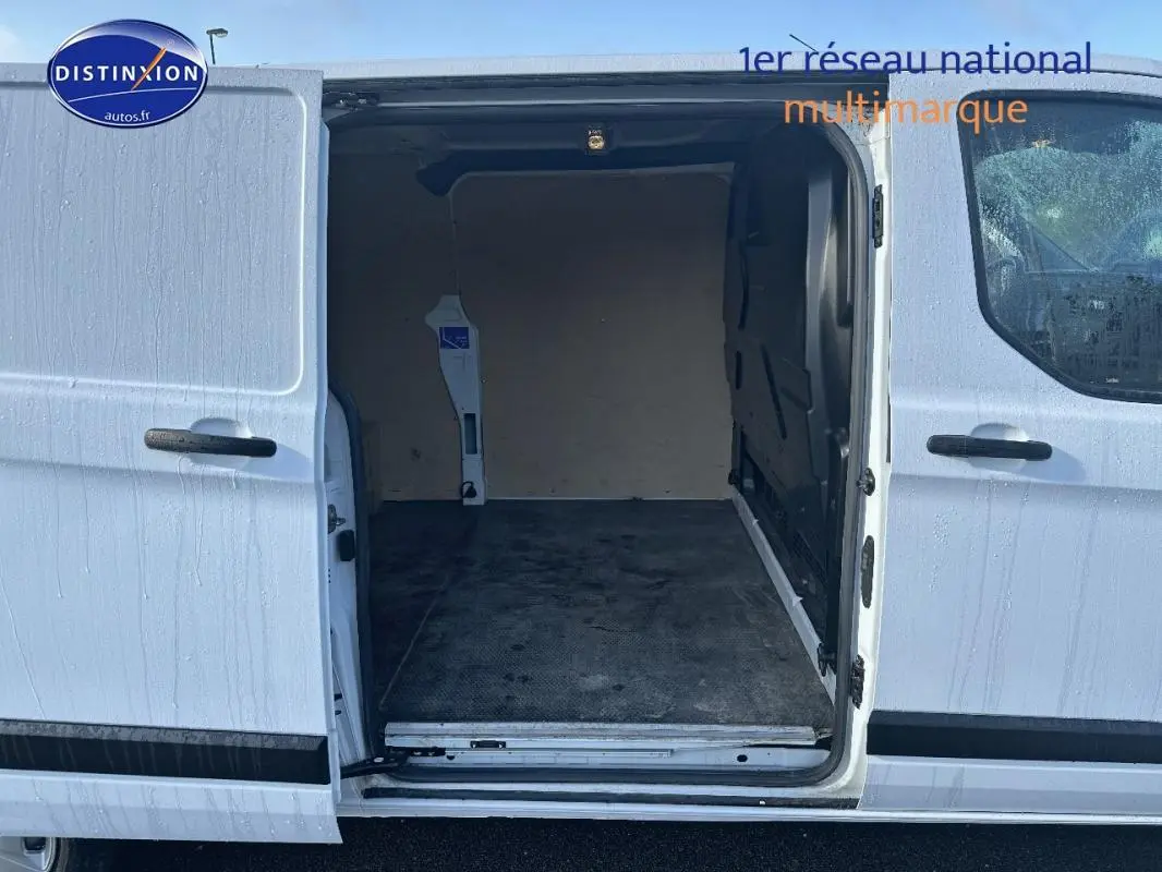Vue latérale droite du fourgon blanc Ford Transit Custom avec porte latérale ouverte montrant l'espace de chargement vide.