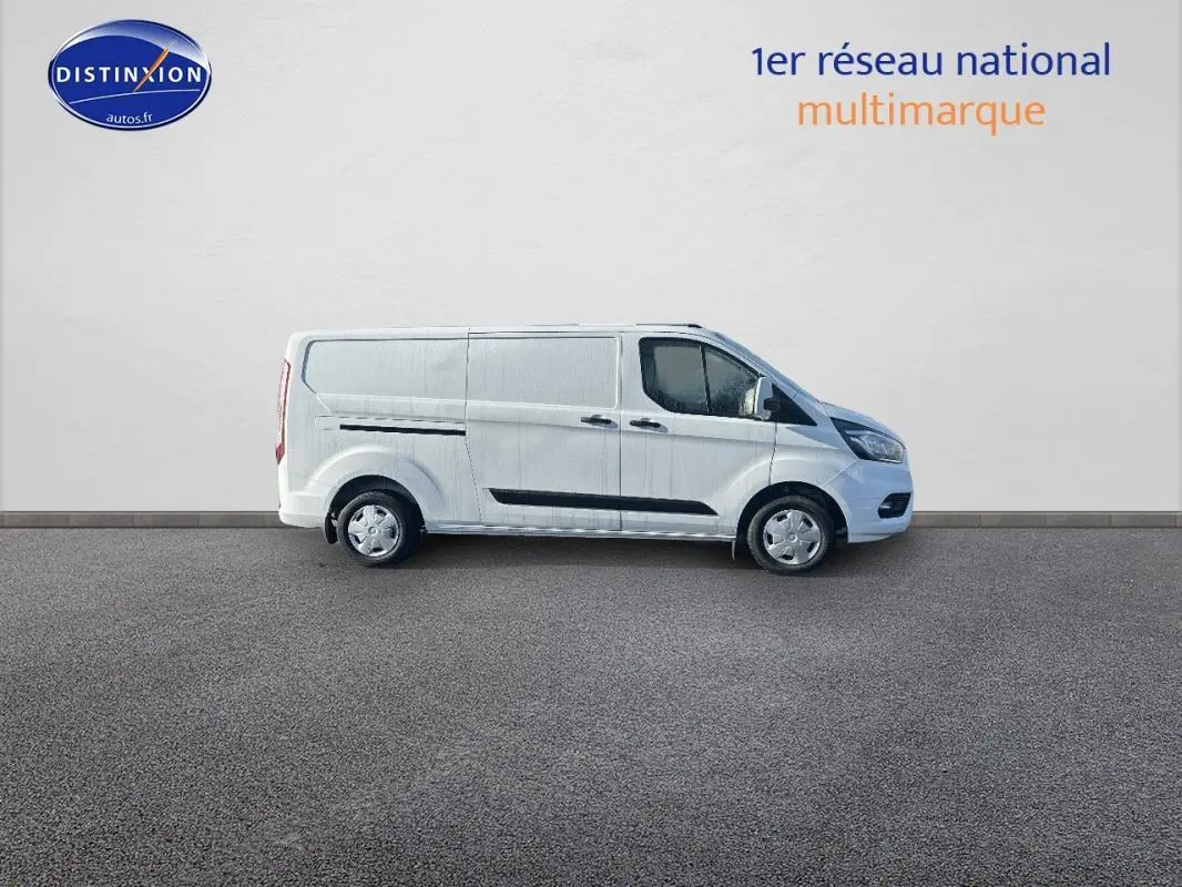 Fourgon Ford Transit Custom blanc vu de profil côté droit, avec porte latérale et vitres surteintées.