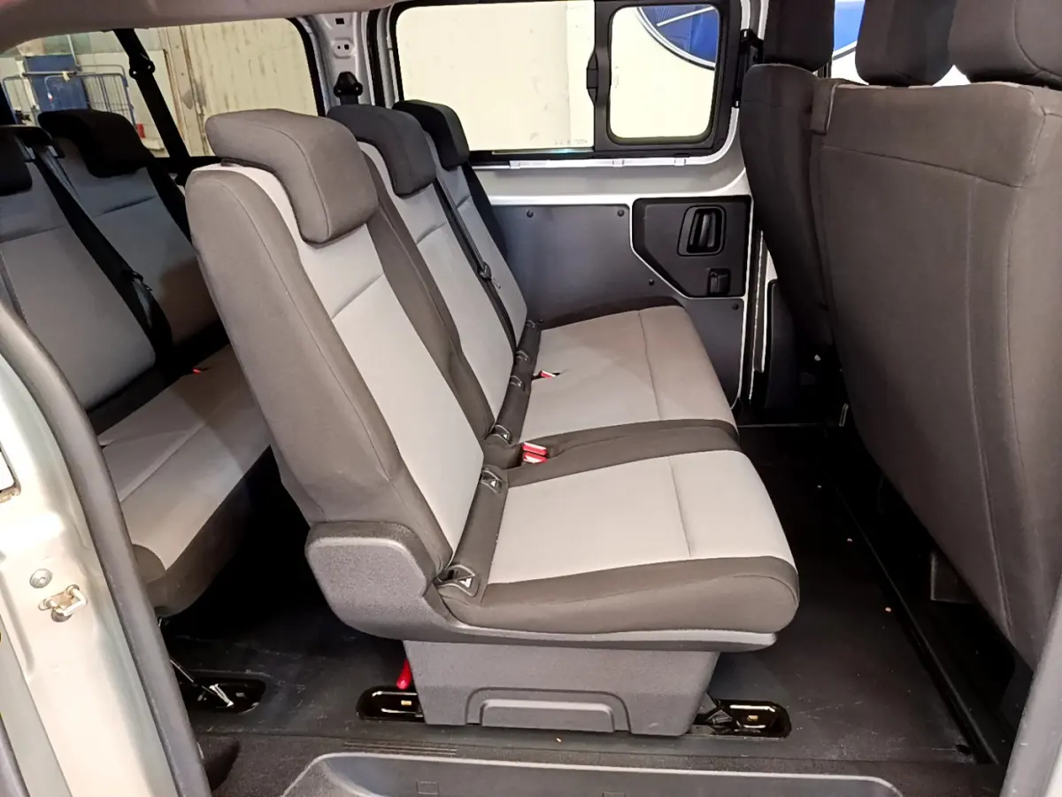 Vue latérale intérieure des sièges arrière gris clair et foncé du Toyota Proace Verso 2019, avec portière ouverte.