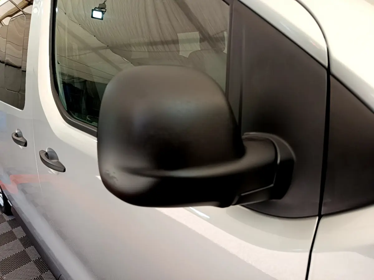 Gros plan sur le rétroviseur noir côté droit d’un Toyota Proace Verso gris clair, vue latérale avant.