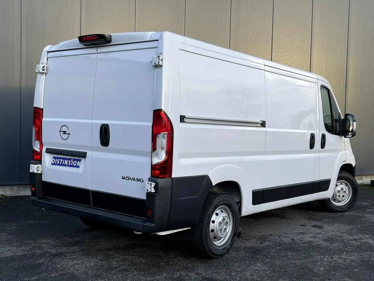 Vue 3/4 arrière droite d'un fourgon Opel Movano blanc avec porte latérale coulissante et hayon double battant.