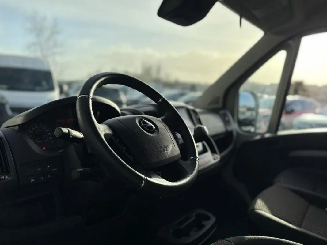 Intérieur de l’Opel Movano Fourgon 2023, vue côté conducteur sur le volant et tableau de bord noir.
