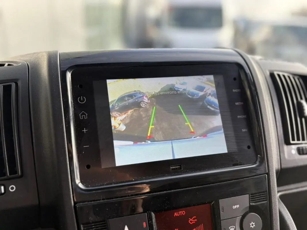 Écran central de l’Opel Movano Fourgon blanc montrant la caméra de recul avec les lignes de guidage colorées.