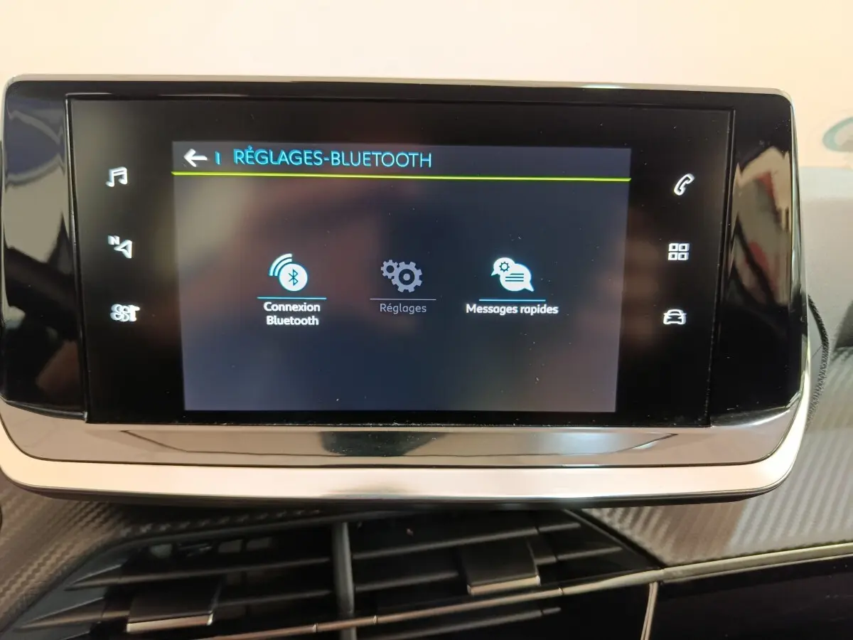 Écran tactile central de la Peugeot 208 électrique Active Business R affichant les réglages Bluetooth, intérieur noir.