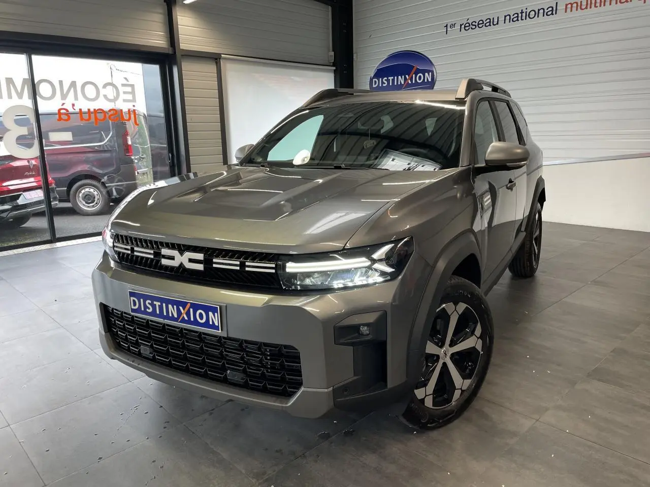 Vue 3/4 avant droite du Dacia Bigster gris schiste avec calandre noire et jantes alliage 18 pouces diamantées.