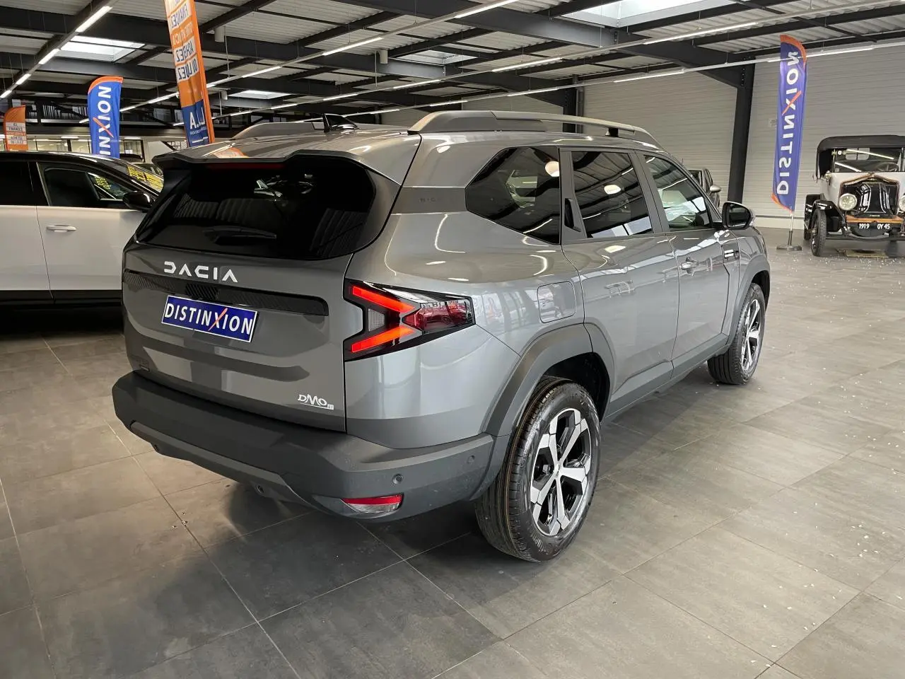 Vue 3/4 arrière droite du Dacia Bigster gris schiste avec jantes alliage et signature lumineuse LED distinctive.