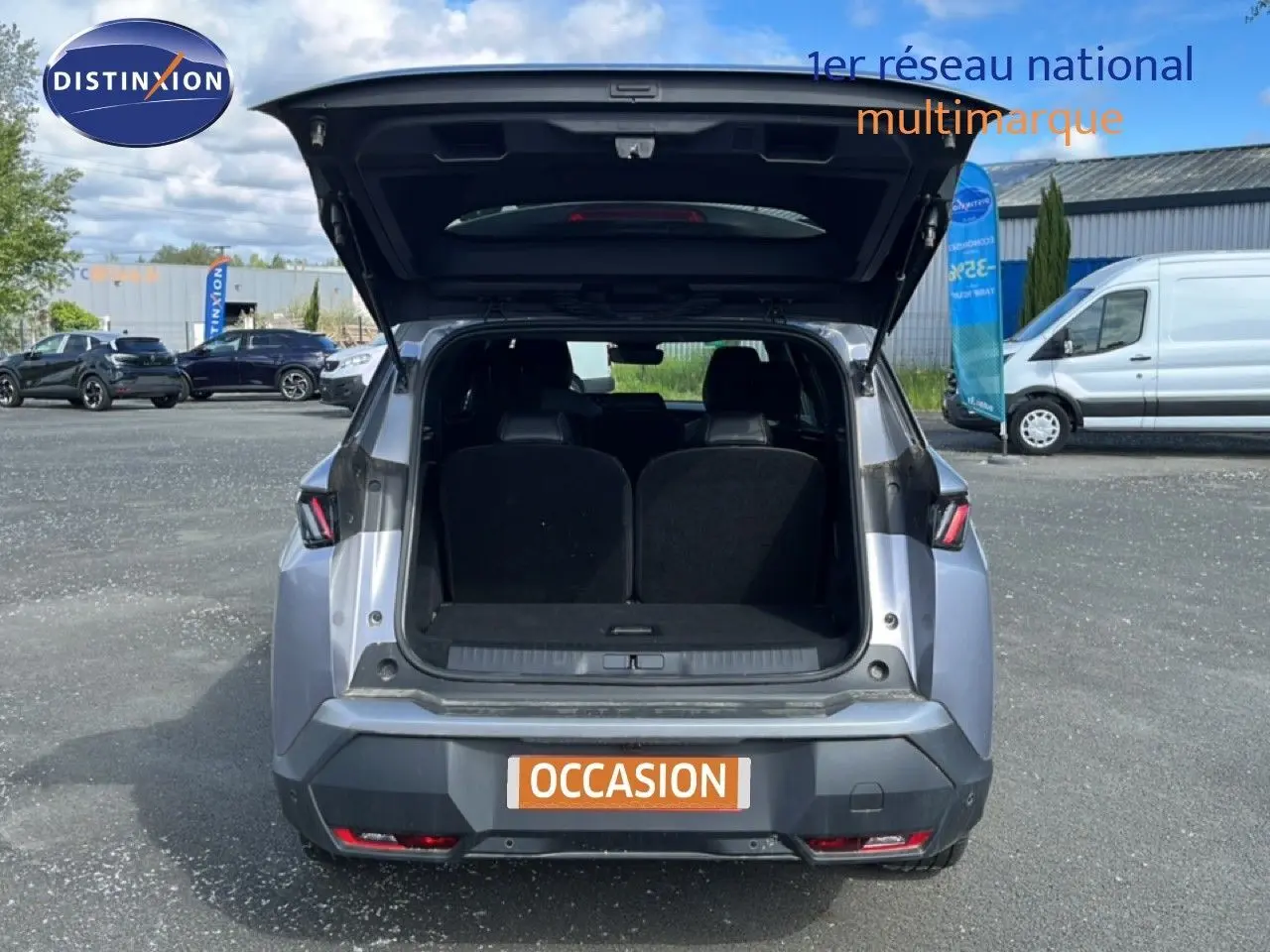 Vue arrière d’un Peugeot 5008 gris Artense métal 2025 avec coffre ouvert montrant l’espace de chargement.