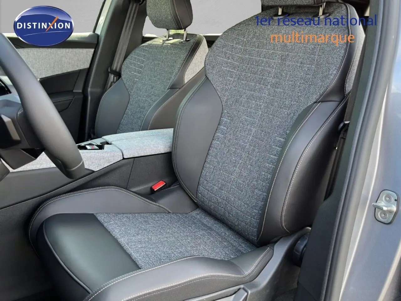 Vue intérieure sur les sièges avant gris tissu et cuir du Peugeot 5008 Hybrid 2025, avec portière ouverte côté droit.