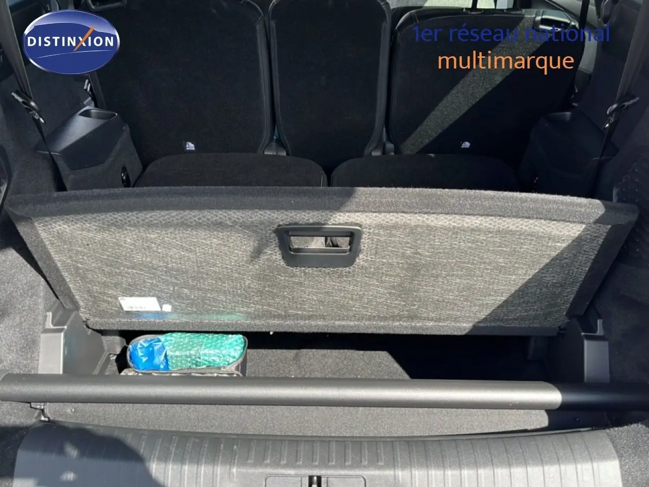 Coffre ouvert du Peugeot 5008 gris Artense, montrant le compartiment de rangement sous plancher et les sièges arrière rabattus.