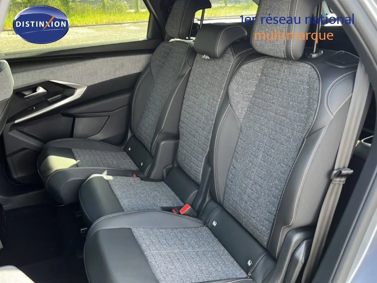 Vue latérale intérieure montrant les sièges arrière en tissu gris et cuir noir du Peugeot 5008 Hybrid 2025 gris Artense métal.
