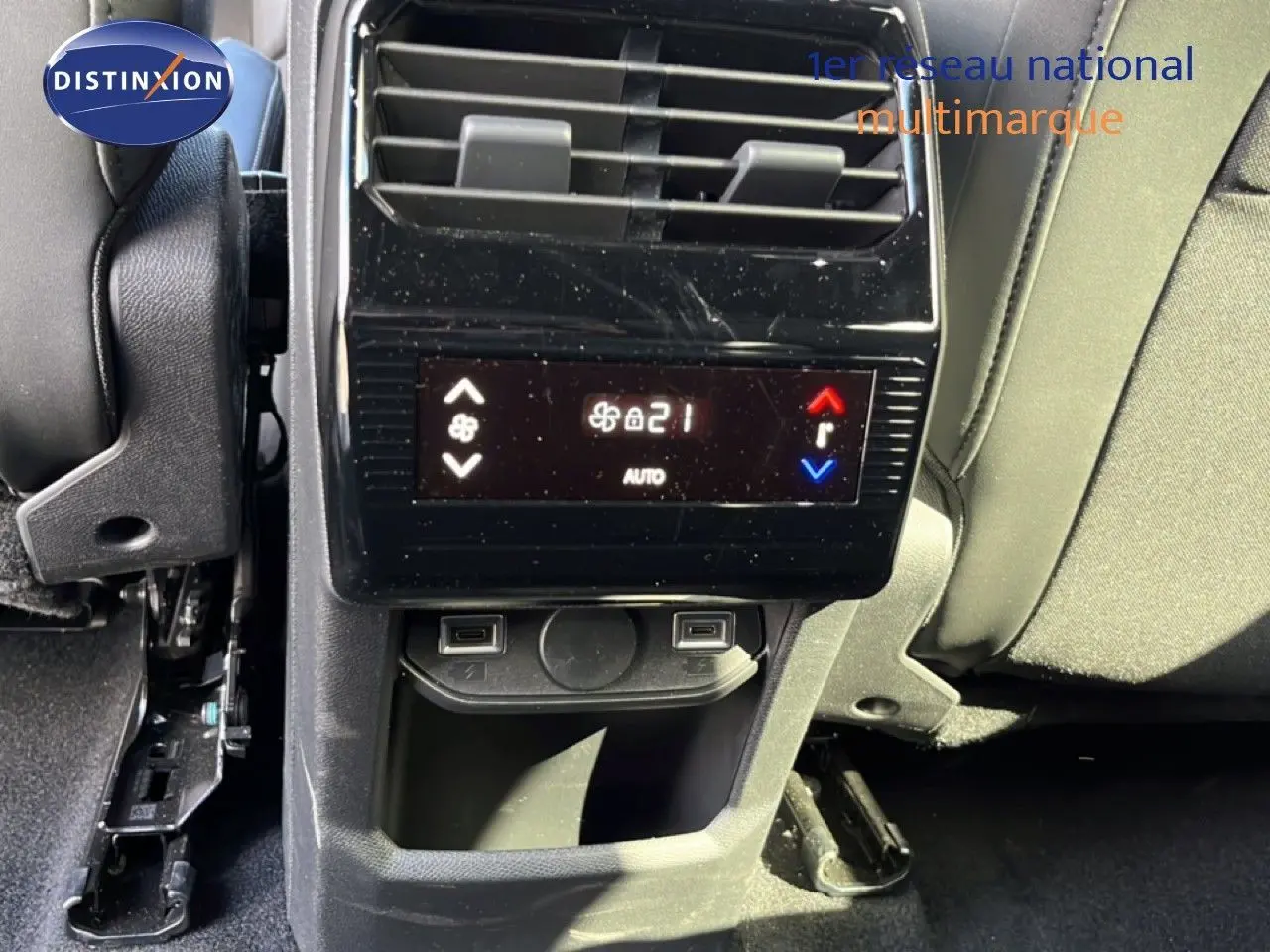 Vue rapprochée de la console arrière du Peugeot 5008 gris Artense, avec commandes de climatisation et ports USB visibles.