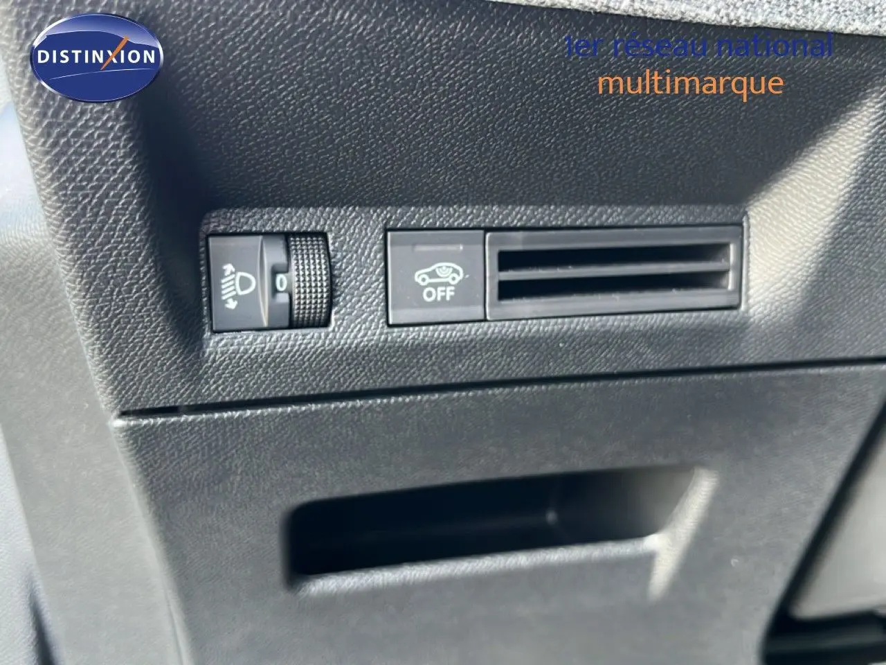 Détail intérieur montrant les commandes de réglage des phares et l'aération côté conducteur du Peugeot 5008 gris Artense 2025.