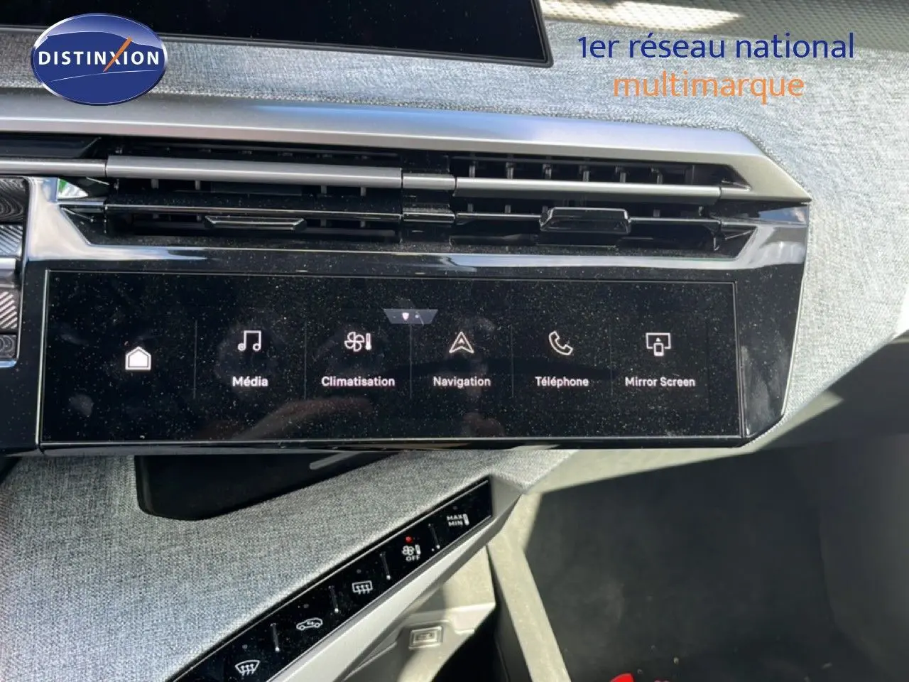 Vue rapprochée du tableau de bord du Peugeot 5008 Hybrid gris Artense, avec écran tactile multimédia et commandes climatisation.