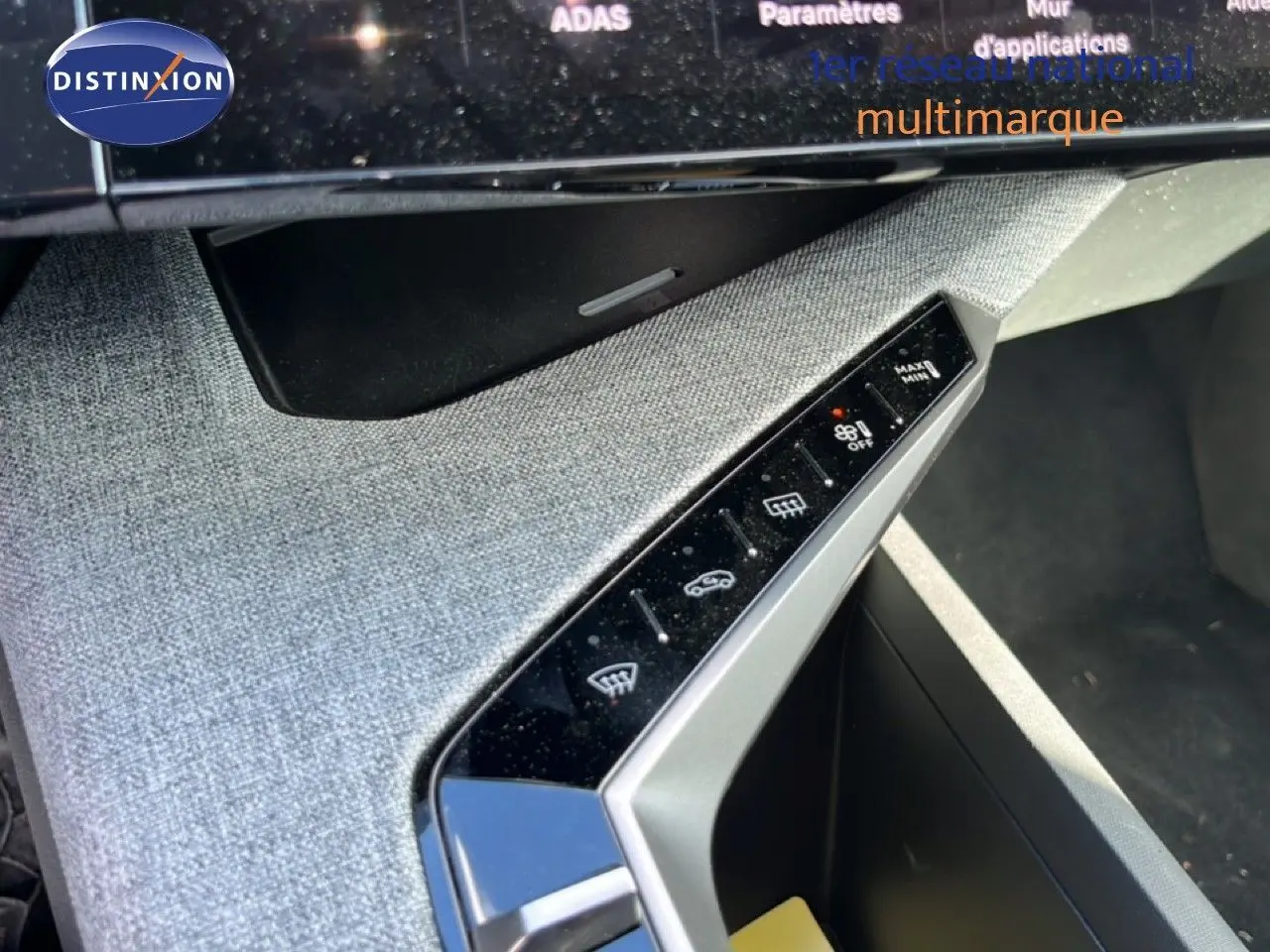 Détail de la console centrale grise tissu du Peugeot 5008 Hybrid 2025, avec commandes tactiles et finition moderne.